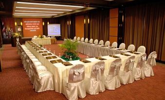 a conference room set up for a meeting , with tables and chairs arranged in a semicircle at Kuiburi Hotel & Resort