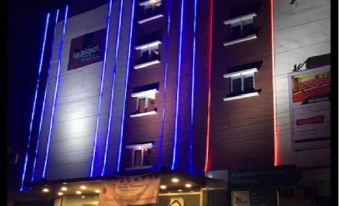 a tall building with blue and red lights illuminating it , creating a bright and vibrant atmosphere at Budget Hotel
