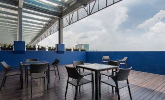 a rooftop patio with several chairs and tables arranged for people to enjoy the view at Citadines DPulze Cyberjaya