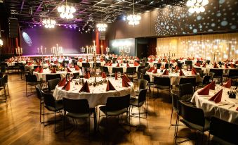 a large dining room with many round tables and chairs set up for a formal event at Radisson Blu Caledonien Hotel, Kristiansand