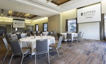 a large dining room with multiple round tables and chairs set up for a formal event , possibly a conference or meeting at Pullman at Sydney Olympic Park