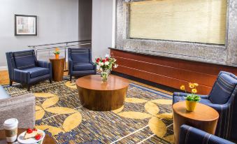 a modern hotel lobby with wooden furniture , floral arrangements , and a large screen on the wall at Courtyard by Marriott Los Angeles Pasadena/Monrovia