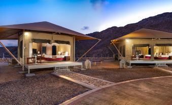 a resort with two tents , one on the left and the other on the right , surrounded by mountains at Ras Al Jinz Turtle Reserve