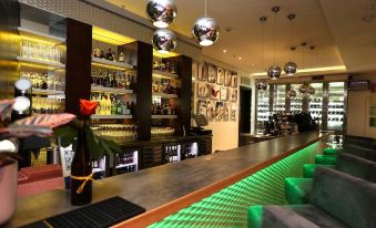 a bar with a green and white color scheme , surrounded by various bottles and glasses at Hotel Verde Cape Town Airport