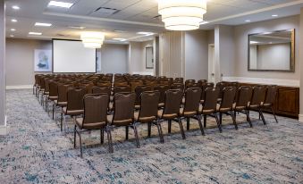a large conference room with rows of chairs arranged in a semicircle , ready for an event at HIlton Garden Inn Roanoke