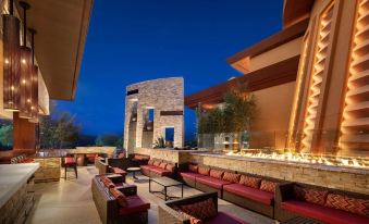 an outdoor patio with a fire pit and multiple couches , creating a cozy atmosphere for people to relax and enjoy the evening at Gila River Resorts & Casinos – Vee Quiva