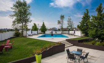 a backyard with a swimming pool , patio furniture , and a grassy area under a clear blue sky at Shillingford Bridge Hotel