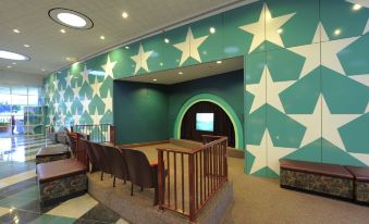 a room with a green and white star wall , wooden stairs , and a projector screen at Disney's All-Star Movies Resort