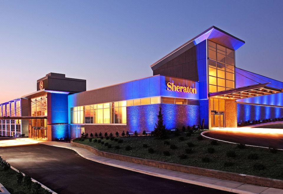 a large , modern building with a blue and orange facade is the sheraton hotel at Sheraton Valley Forge King of Prussia