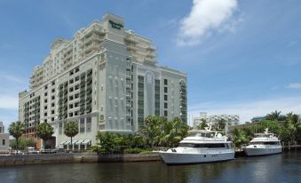 a large white yacht docked next to a tall building on the side of a river at Riverside Hotel