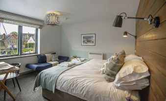 a well - decorated bedroom with a large bed , couch , and window , creating a cozy atmosphere for relaxation and enjoyment at Lock Chambers, Caledonian Canal Centre