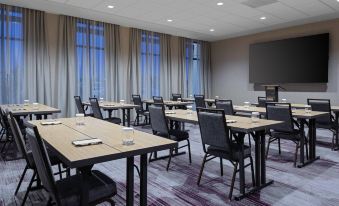 a conference room with tables and chairs , a television , and large windows , ready for meetings or presentations at Courtyard Pasco Tri-Cities Airport