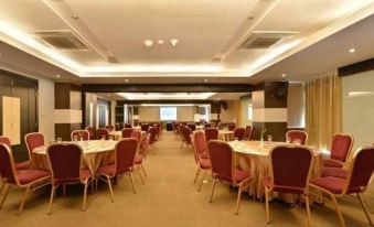 a large conference room with multiple tables and chairs arranged for a meeting or event at Golden Flower by Kagum Hotels