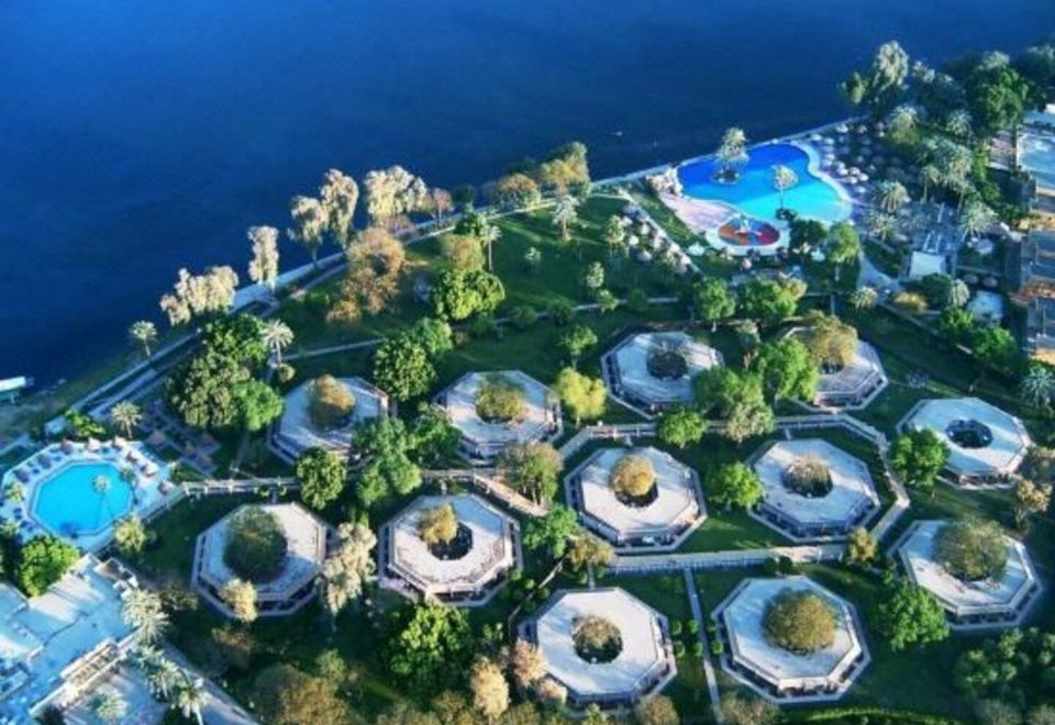 an aerial view of a resort with multiple buildings and a swimming pool surrounded by lush greenery at Jolie Ville Hotel & Spa Kings Island Luxor