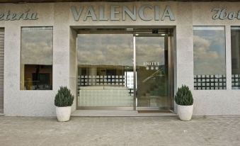 "the entrance to a building with the name "" valencia "" displayed above it , along with two white pots on either side of the door" at Hotel Valencia