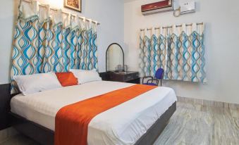 a cozy bedroom with a white bed , orange and white bedding , and blue curtains on the windows at Holiday Inn