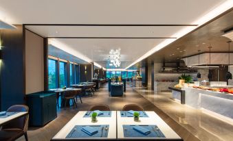 A modern restaurant with spacious dining room featuring large windows and tables at Crowne Plaza Shanghai Hongqiao