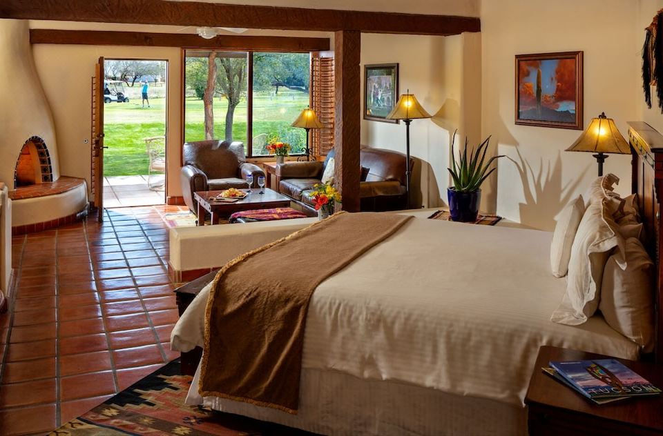 a spacious bedroom with a large bed and a view of a golf course outside the window at Tubac Golf Resort & Spa