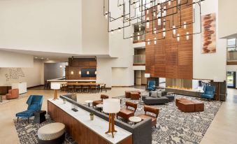 a modern hotel lobby with various seating options , including couches and chairs , as well as a bar area at Doubletree by Hilton Columbus Dublin