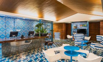 a modern and stylish lounge area with blue and white checkered floor , blue chairs , and a large wall mural at Astoria Palawan