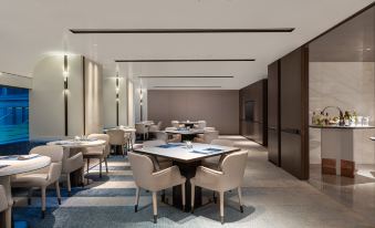 The restaurant features spacious tables and chairs arranged in the center, creating an open concept dining area at Crowne Plaza Shanghai Hongqiao