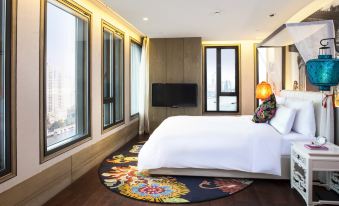 The apartment or bedroom features a spacious bedroom with large windows and a TV on the bed at Hotel Indigo Shanghai on The Bund