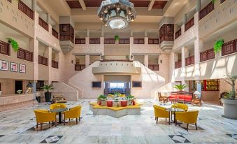 a large , modern hotel lobby with a chandelier hanging from the ceiling , a marble floor , and various seating areas at Grand Mercure Petra