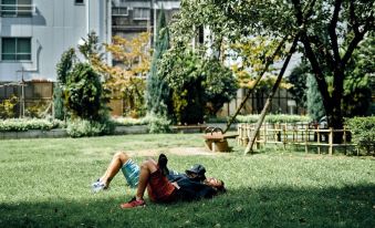 two young boys are laying on the grass in a park , enjoying their time together at Nohga Hotel Akihabara Tokyo