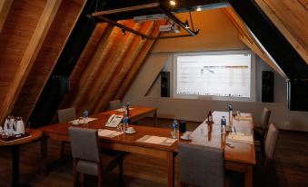 a conference room with a wooden table , chairs , and a projector screen displaying information at Los Cerros del Chalten Boutique Hotel