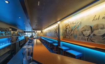 a bar with blue lighting , wooden tables and chairs , and a mural on the wall at Hotel Post