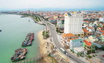 aerial view of a city with a river , boats , and buildings near a tall building at Riverside Hotel Quang Binh