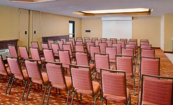a conference room with rows of red chairs and a projector screen at the front at Residence Inn Palo Alto Los Altos