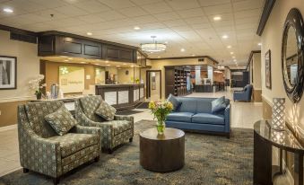 a large hotel lobby with multiple couches , chairs , and tables , creating a comfortable and inviting atmosphere at Best Western Plus Strongsville Cleveland