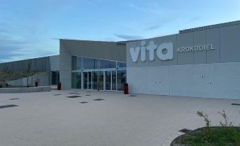 "a large white building with a sign that reads "" vita krokodier "" in front of it" at Hotel Acropolis