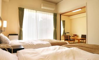 a hotel room with two beds , one on the left and one on the right side of the room at Wisterian Life Club Nojiriko