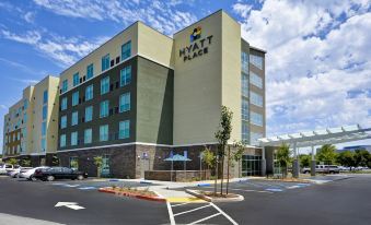a large building with a hyatt place sign on it , located in a city setting at Hyatt Place Fresno