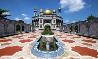 a large , ornate building with a golden dome and blue and white tiles surrounding a fountain at Mulia Hotel