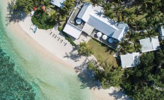 aerial view of a beach house surrounded by palm trees , with a pool visible in the background at Holiday Inn Mauritius Mon Tresor