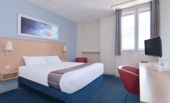 a hotel room with a bed , desk , and chair , along with a tv on the wall at Travelodge Nottingham Trowell M1