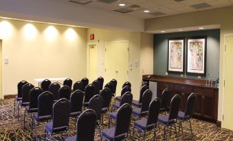 a conference room with rows of chairs arranged in a semicircle , and a podium at the front of the room at Hampton Inn & Suites by Hilton Stroudsburg Pocono Mountains