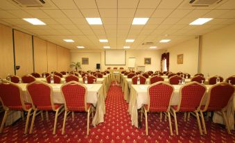 a large conference room with multiple tables and chairs arranged for a meeting or event at Hotel Corsica & Spa Serena