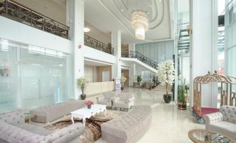a large , well - lit hotel lobby with multiple couches and chairs , creating a comfortable and inviting atmosphere at Savero Hotel Depok