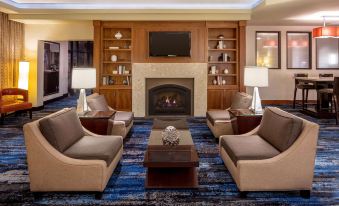 a well - decorated living room with comfortable seating , a fireplace , and a television mounted on the wall at DoubleTree Suites by Hilton Minneapolis