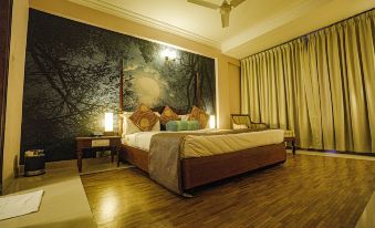 a large bed with a wooden headboard is in a room with a tree mural on the wall at Casino Hotels Ltd