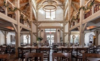 a large dining room with wooden tables and chairs arranged for a group of people to enjoy a meal together at Briar Barn Inn