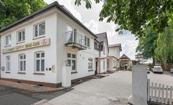 "a white building with a sign that reads "" cafe "" on the side of the road" at Hotel Bellevue