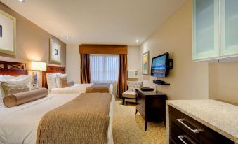 a modern hotel room with two beds , a desk , and a tv , decorated in neutral colors at Red Lion Inn and Suites Victoria