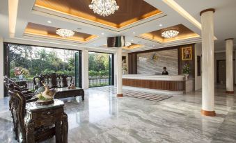 a luxurious hotel lobby with marble flooring , a reception desk , and a large chandelier hanging from the ceiling at RK Riverside Resort & Spa (Reon Kruewal)