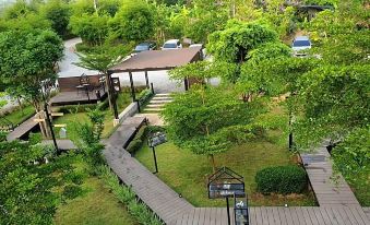 an aerial view of a residential area with a house surrounded by trees and a parking lot at Baan Rai Darun Home Stay and Scenery Raft