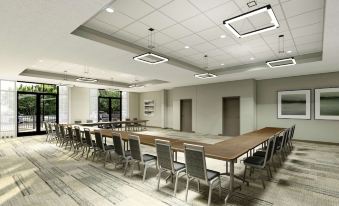 a large conference room with multiple rows of chairs arranged in a semicircle , creating an intimate setting for meetings at Cambria Hotel Detroit-Shelby Township